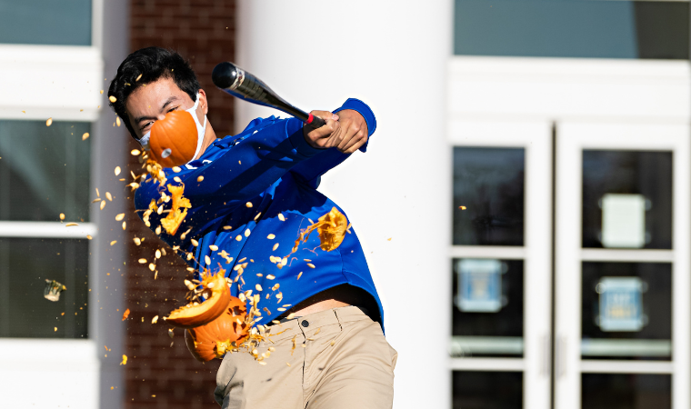 Student hitting pumpkin